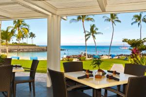 una mesa con sillas y vistas al océano en KBM Resorts 4-Bedroom Islands at Mauna Lani Collection Multi-Unit Listing Steps from One Another Garden Views 2 Free Rental Cars IML-D3E4, en Waikoloa