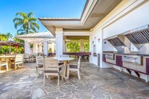 Un patio al aire libre con mesa y sillas. en KBM Resorts 4-Bedroom Islands at Mauna Lani Collection Multi-Unit Listing Steps from One Another Garden Views 2 Free Rental Cars IML-D3E4, en Waikoloa