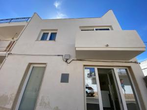 a white building with a window and a door at Isid'Oro Rooms - 50m dal mare in Sant'Isidoro
