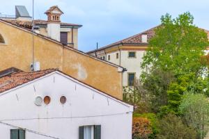 an old white building in front of buildings at La Mansardina Padovana - Historic Center in Padova