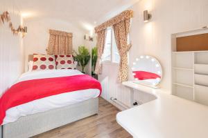 a bedroom with a red and white bed and a tub at East Sussex Manor - Sleeps 12 - Hot Tub & Parking in Hailsham