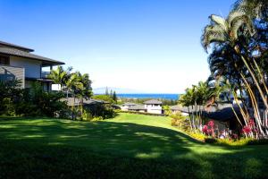 カパルアにあるKBM Resorts Spacious 3-Bedroom Kapalua Golf Collection Multi Unit Listing Same Enclave Ocean Views 2 Free Rental Cars KGV-22P2T5のヤシの木や家々が生い茂る緑の庭