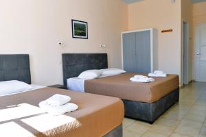 a hotel room with two beds with towels on them at Vanas Apartments in Spetses