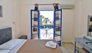 a bedroom with a bed and a view of a pool at Vanas Apartments in Spetses