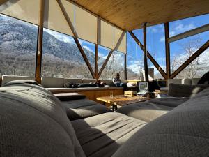 a living room with large windows and a person sitting on a couch at AvA Refugios Malalcahuello in Malalcahuello