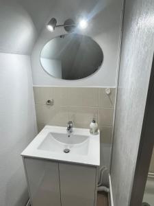 un bagno con un lavandino bianco e uno specchio di Super appartement a Malesherbes