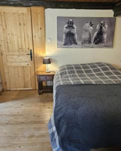 a bedroom with a bed and a picture of dogs at Domaine du Petit Dorsbach in Soultzbach-les-Bains