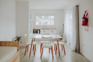 a white kitchen with a white table and chairs at Hol Gok Patagonia in Esquel