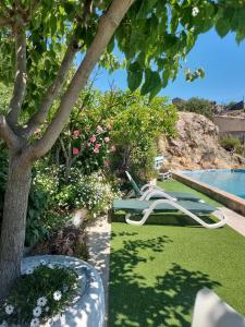 a swimming pool with a lawn chair next to a tree at Casa Rural Casaplana, grupos grandes, 1500m2 de casa, piscina privada y patio, 2 barbacoas, Zona Prepirineo in Calasanz