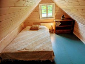 a bedroom with a bed in a wooden attic at Cosy Cabin close to Lake in Ludvigsborg