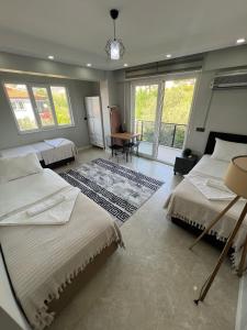a bedroom with two beds and a table and windows at Panorama house in Denizli