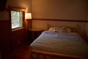a small bedroom with a bed and a window at Rustic Beaverfoot Lodge Room N4 in Parson