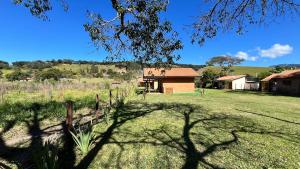 a house in the middle of a field at Chalés Bons Ventos in São Bento do Sapucaí