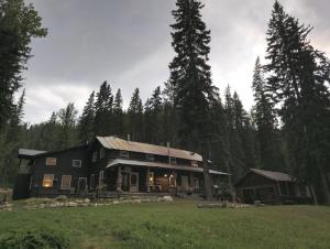 a large wooden house in the middle of a field at Rustic Beaverfoot Lodge Room N5 in Parson