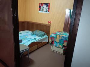 a small bedroom with a bed and a chair at Стаи на пъпа на Варна, входа на Морската градина in Varna City