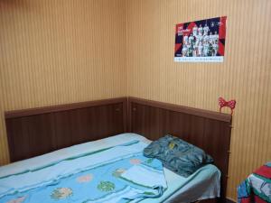 a small bed in a room with a picture on the wall at Стаи на пъпа на Варна, входа на Морската градина in Varna City