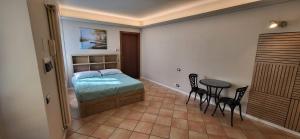 a bedroom with a bed and a table and chairs at Appartamento nel cuore di Brivio in Brivio
