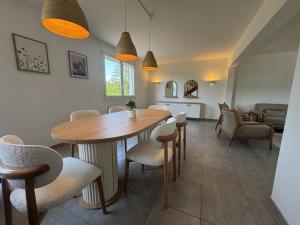 a dining room and living room with a table and chairs at La Porte du Circuit - 8pers - Confort - Rêve au Mans in Bel Air