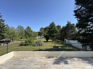 a fence in front of a park with trees at La Porte du Circuit - 8pers - Confort - Rêve au Mans in Bel Air