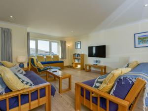 Un dormitorio con dos camas y una sala de estar. en 12 Burgh Island Causeway, en Kingsbridge