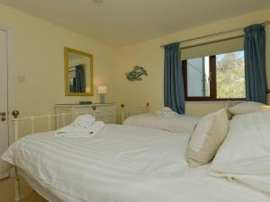 Un dormitorio con dos camas y una ventana. en 12 Burgh Island Causeway, en Kingsbridge
