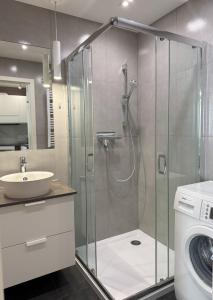 W łazience znajduje się prysznic, umywalka i pralka. w obiekcie Apartament Bałtyk - WAP w Świnoujściu