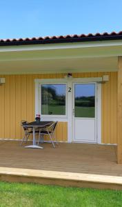 a patio with a table and two doors on a house at Björkängs Vandrarhem in Tvååker