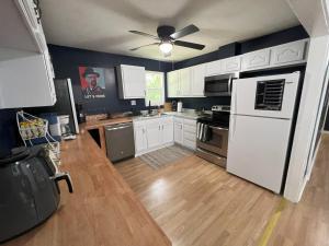 a kitchen with white cabinets and a white refrigerator at Bluebird Liberty Cottage in Saint Robert