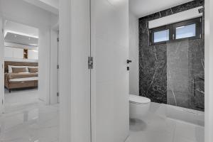 Un baño blanco con inodoro y un dormitorio. en Luxury Apartment Nikolina with Garage, en Tučepi 33 fotos más