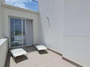 a balcony with two white chairs and a window at Just Light in San Leone