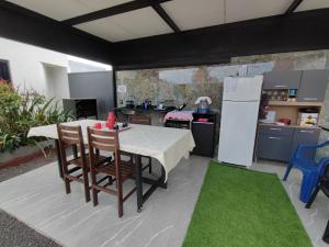 a kitchen with a table with chairs and a refrigerator at Quarto Califórnia in Campo Novo do Parecis