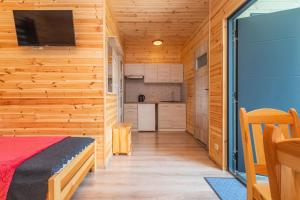 a bedroom with a bed and a tv in a wooden wall at Domek 4 osobowy in Stegna