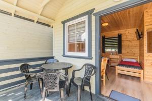 a patio with a table and chairs on a porch at Domek 4 osobowy in Stegna +14 photos