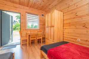 a bedroom with a bed and a dining room at Domek 4 osobowy in Stegna