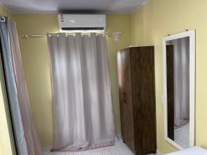 a bathroom with a shower curtain and a mirror at May acomodações in Barreirinhas