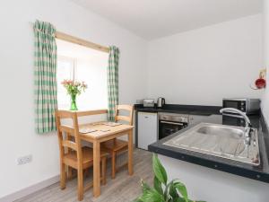 une cuisine avec un évier et une table avec des chaises dans l'établissement Bathach Mor, à Oban 10 autres photos