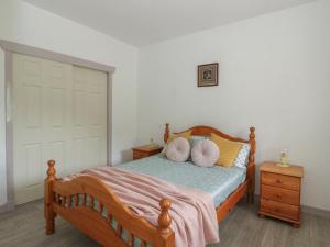 - une chambre avec un lit en bois et des oreillers dans l'établissement Bathach Mor, à Oban