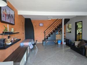 Una sala de estar con un sofá y una escalera. en Casa na Enseada da Pinheira, en Palhoça