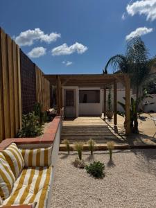 a patio with a bench and a fence and a house at Chambre d'hôtes Villa Calys in Claira