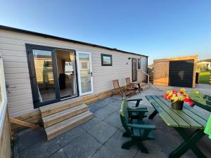 WesterlandPRACHTiG CHALET MEREL的带桌椅的露台和一栋房子