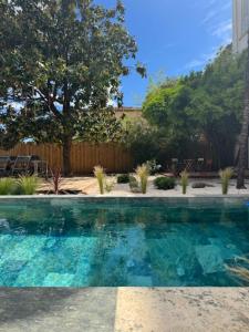 a swimming pool with blue water in a yard at Chambre d'hôtes Villa Calys in Claira