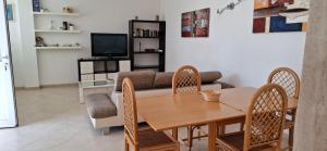 Una sala de estar con una mesa y sillas de madera. en Savelletri Summer House, en Savelletri di Fasano