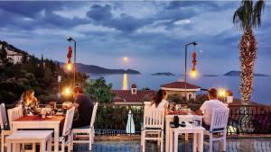a group of people sitting around a table on a patio at Amphora Hotel in Kaş
