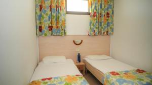 サン・バルトロメにあるLos Cactus Canary Home Rentのカーテンと窓が備わる客室で、ベッド2台が備わります。 +19枚の写真