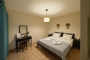a bedroom with a bed and a desk and a bed at Nicolas Beach in Palaiochora