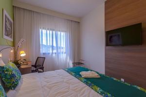 a hotel room with a bed with a flat screen tv at Blue Tree Towers Valinhos in Valinhos