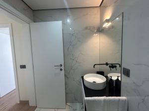 un bagno con lavandino e specchio di Casa aOrta Apartments a Faro