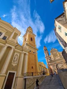 a large building with a clock tower and stairs at La 34 Tiny House with sunny terrace in Menton