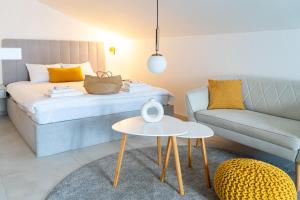 Un dormitorio con una cama, un sofá y una mesa. en Vitas Apartments, en Zaton