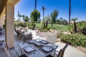 a patio with a table and chairs and a golf course at Resort-Style Amenities at Palm Desert Getaway in Palm Desert